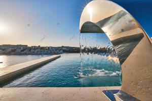 una fontana con una città sullo sfondo di Lux Villa with Pool-Hosted by Sweetstay a San Pawl il-Baħar