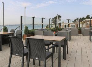 a table and chairs on a patio with a view of the water at Charming and peaceful 2-Bed Chalet in Hampshire in Warsash