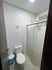 a bathroom with a toilet and a glass shower at Hotel PetroShop in Palmas