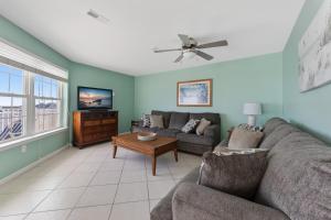 uma sala de estar com um sofá e uma televisão em Nw Condo W Ocean View, Sundeck, Pool em North Wildwood