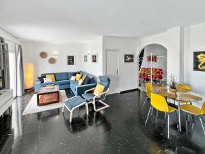 プエルト・デ・ラ・クルスにあるLarge Penthouse with Sunny Terraceのリビングルーム(青いソファ、黄色の椅子付)