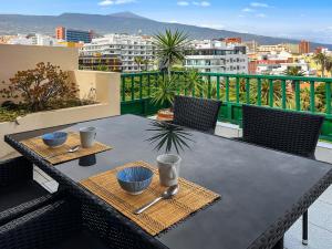 プエルト・デ・ラ・クルスにあるLarge Penthouse with Sunny Terraceの市街の景色を望むバルコニー(テーブル付)