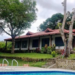 uma casa com uma piscina em frente em Finca la lomita de golf em Melgar