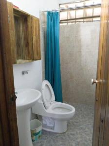 uma casa de banho com um WC branco e um lavatório. em Finca la lomita de golf em Melgar