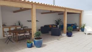 a patio with potted plants and a table and couch at White Guest House in Peniche