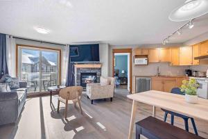 cocina y sala de estar con mesa y sala de estar en Lux 2BR 5BD Suite Mountain view! en Canmore