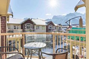 a balcony with a table and chairs and mountains at Lux 2BR 5BD Suite Mountain view! in Canmore