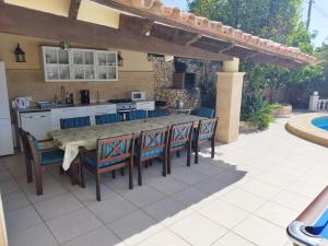 een patio met een tafel en stoelen en een keuken bij villa Belucra,10p,seaview,jacuzzi,pool in Calpe
