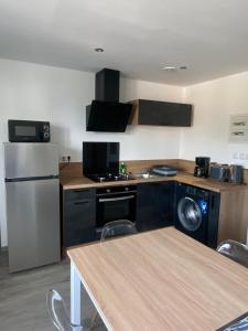 a kitchen with a refrigerator and a table with chairs at Appartement 21 in La Roche-Posay