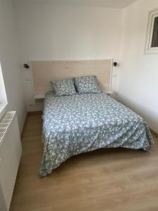 a bedroom with a bed with a comforter and pillows at Appartement 21 in La Roche-Posay