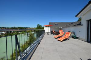 PremにあるFerienwohnung am Lech - Heidrun s Nestの水辺の景色を望むバルコニー(オレンジ色の椅子付)