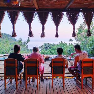 Reflections Camp في فاراليا: مجموعة من الناس يجلسون على طاولة في السطح