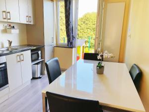 una cocina con una mesa blanca con sillas y una ventana en Sweet home en Bruselas