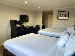 a hotel room with two beds and a desk at Rodeway Inn National City San Diego South in National City