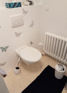 a white toilet in a room with butterflies on the wall at Ferienwohnung "Am Johannisberg" in Witzenhausen +6 photos
