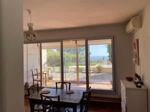 uma sala de jantar com uma mesa e uma grande janela em Appartement de caractère vue mer panoramique em Bandol