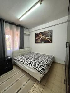 a zebra print bed in a room with a window at 3-х комнатная квартира у моря в Хайфе in Haifa