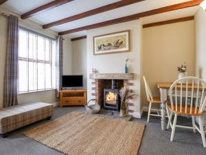 a living room with a fireplace and a tv at The Cottage 16 Northside in Patrington