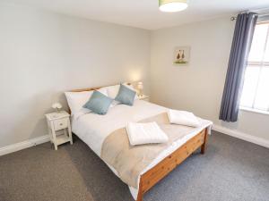 a bedroom with a large bed with blue pillows at The Cottage 16 Northside in Patrington
