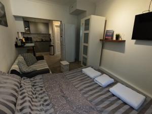een kleine kamer met een bed en een bank bij Studio Apartment in Kew in Kew