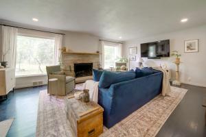 a living room with a blue couch and a fireplace at Stylish Willoughby Hills Retreat with Fireplace! 