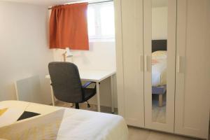 - une chambre avec un bureau, une chaise et un lit dans l'établissement T2 calme aux portes de Brest, à Bohars