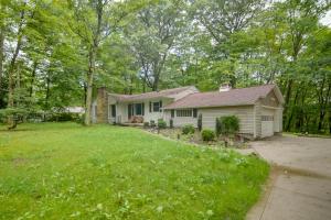 a white house with a yard and trees at Stylish Willoughby Hills Retreat with Fireplace! 