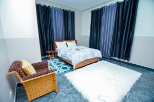 1 dormitorio con 1 cama, 1 sofá y 1 silla en Pai4 Apartments 2 en Dodoma