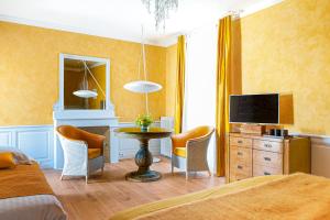 a bedroom with a bed and a table and chairs at Chambres d'Hôtes Eden Ouest in La Rochelle