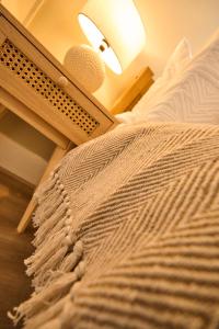 a bedroom with a bed with a table and a lamp at Wood End View - Traditional Top-and-Bottom House in Hebden Bridge