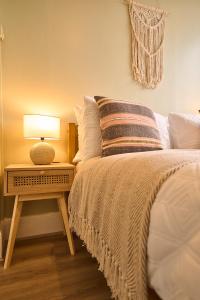 una camera da letto con un letto con una lampada su un comodino di Wood End View - Traditional Top-and-Bottom House a Hebden Bridge