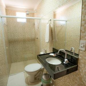 a bathroom with a sink and a toilet and a shower at Pousada Villa Costeira in Maragogi