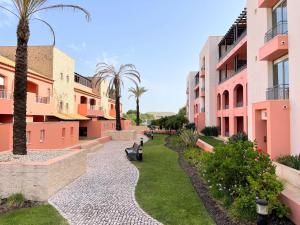 a walkway between two buildings with palm trees at Penthouse Victoria in Vilamoura