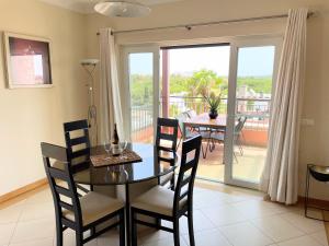 uma sala de jantar com mesa e cadeiras e uma varanda em Penthouse Victoria em Vilamoura