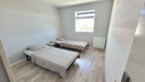 - une petite chambre avec 2 lits et une fenêtre dans l'établissement Cosy Home Paris, à Carrières-sous-Poissy
