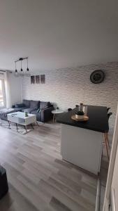 ein Wohnzimmer mit einem Sofa und einem Tisch in der Unterkunft Cosy Home Paris in Carrières-sous-Poissy