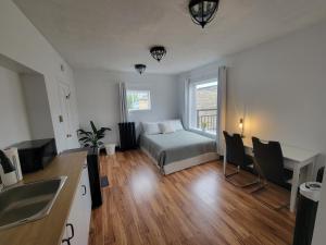 a bedroom with a bed and a kitchen with a sink at Stone House Kenora in Kenora