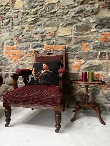 Una silla con la imagen de un hombre al lado de una mesa. en The Old Bushmills Barn, en Bushmills