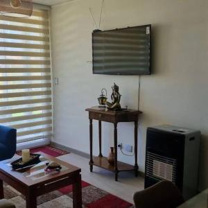 a living room with a table and a television at Depto. Nuevo Algarrobo patio privado in Algarrobo