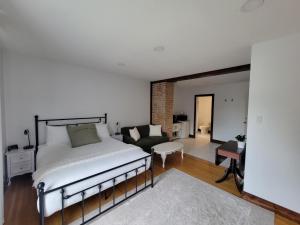 Stone House Kenora في كينورا: غرفة نوم مع سرير وغرفة معيشة