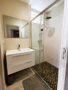 a bathroom with a sink and a glass shower at Soley'Caraibes III in Les Trois-Îlets