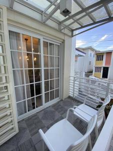 uma varanda com 2 cadeiras, uma mesa e uma janela em Hillside Homestay Subic-Fully Furnished House 3BR em Subic