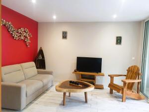 a living room with a couch and a tv at Soley'Caraibes III in Les Trois-Îlets