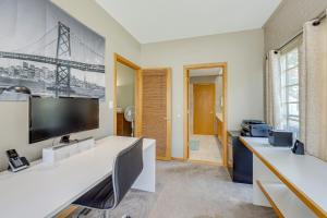 a living room with a large tv on the wall at Central West End Condo Less Than 1 Mi to Forest Park! in Tower Grove