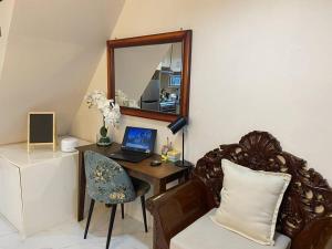 Habitación con escritorio, ordenador portátil y espejo. en Hillside Homestay Subic-Fully Furnished House 3BR en Subic