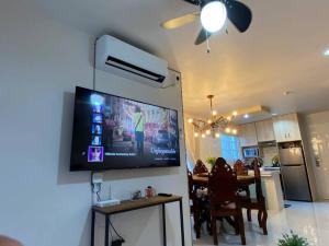 un soggiorno con TV sul muro di una cucina di Hillside Homestay Subic-Fully Furnished House 3BR a Subic