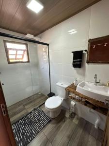 La salle de bains est pourvue d'une douche, de toilettes et d'un lavabo. dans l'établissement Chalés Cânions do Brasil, à Praia Grande