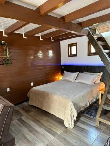 - une chambre avec un lit dans une pièce dotée de murs en bois dans l'établissement Chalés Cânions do Brasil, à Praia Grande