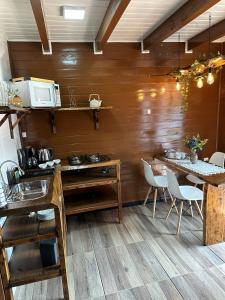 une salle à manger avec deux tables et un four micro-ondes dans l'établissement Chalés Cânions do Brasil, à Praia Grande