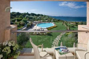 balcón con vistas a la piscina y al océano en L'Ea Bianca Luxury Resort, en Baja Sardinia